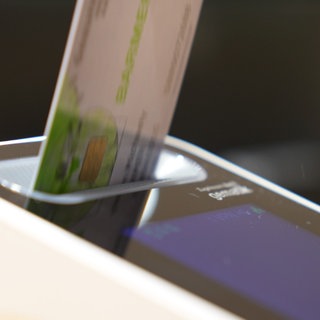 Ein Patient steckt seine Gesundheitskarte in ein Lesegerät.