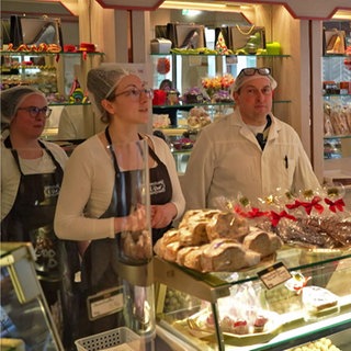 Stephan Raab mit seinen Töchtern  Alicia und Paulina hinter der Theke in ihrer Konditorei