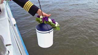 Flussbestattung einer Urne