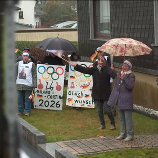 Passanten stehen am Straßenrand und bejubeln Olympiasiegerin Jacqueline Pfeifer