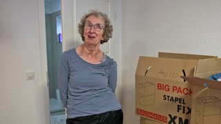 Ute Jantzer ist an Parkinson erkrankt und steht neben Umzugskartons in ihrem neuen Zuhause der Starck-Stiftung in Schweighofen