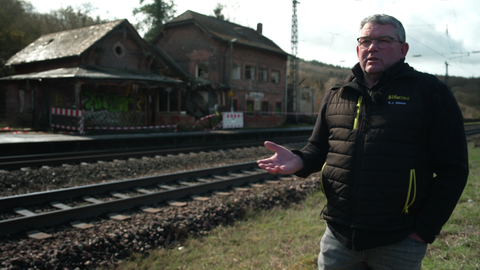 Der Bürgermeister von Bengel, Karl-Josef Simon, steht vor dem alten Bahnhof der Gemeinde. Das Gebäude wird zum Lost place und verfällt,deshalb wird ein Käufer gesucht, der sich um den Abriss oder Umbau kümmert.