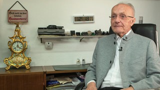 Mann sitzt an einem Schreibtisch