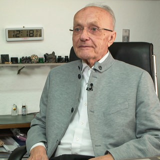 Mann sitzt an einem Schreibtisch