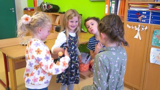 Kinder spielen mit einem Tischtennisball