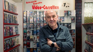 Mann steht in einer Videothek