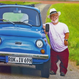 Volker Langguth-Wasem auf einem Foto neben seinem Auto
