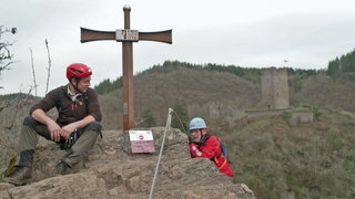 Zwei Kletterer erreichen den Gipfel des Burgen-Klettersteigs Manderscheid