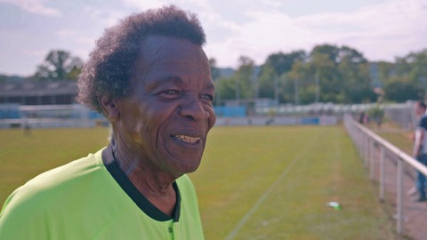 Schiedsrichter steht auf einem Fußballfeld.