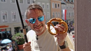 Christian Schuster hat beim Brezelfest in Speyer auf seinem Balkon eine Brezel gefangen