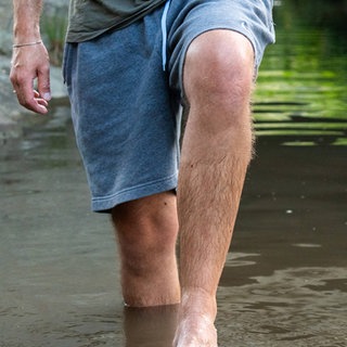Person steht bis zu den Knien im Wasser