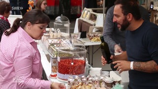 Eine Frau probiert bei einem Stand auf einem Street-Food-Festival