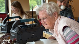 Frau sitzt an einem Radio