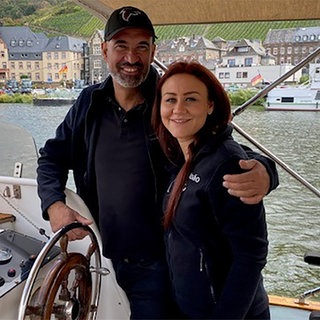 Mann und Frau stehen auf einem Boot auf der Mosel