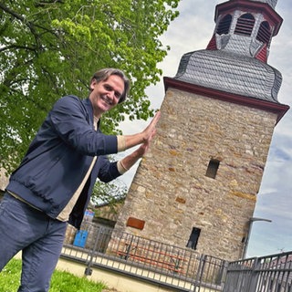 Landesschau-Reporter Marius Zimmermann "stützt" den schiefen Turm von Gau-Algesheim