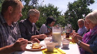 Leute an langer Tafel
