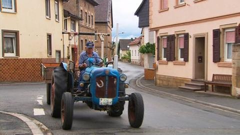 Traktor fährt durch Straße