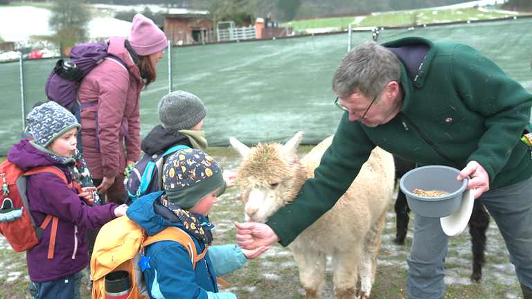 Alpakazüchter Enno ten Kate mit Kindern aus der Waldkita.