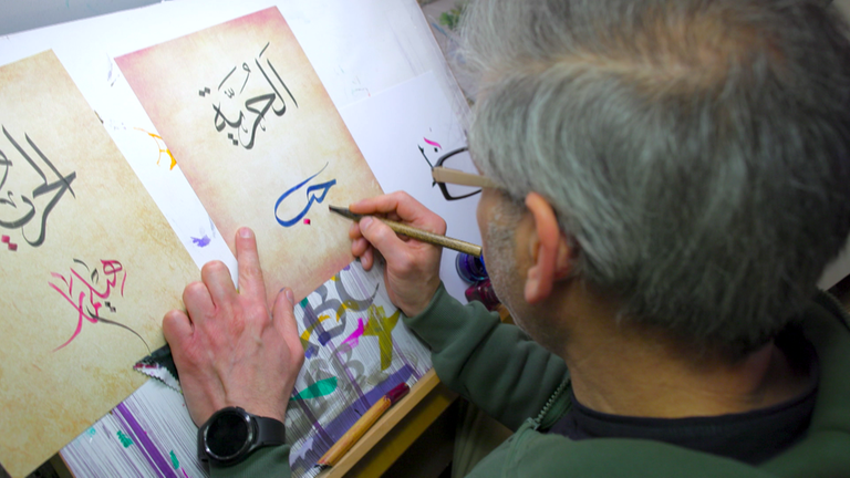 Adel Sudany beim Gestalten arabischer Kalligrafien