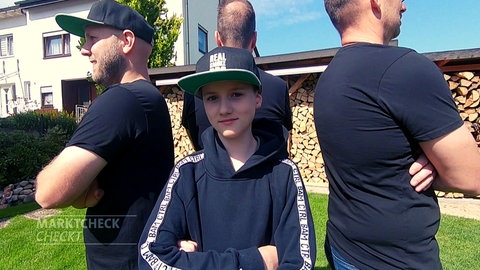 Drei Männer und ein Junge stehen Rücken an Rücken - sie testen für Marktcheck Grills von Weber, Rösle, Landmann, Bauhaus, Activa