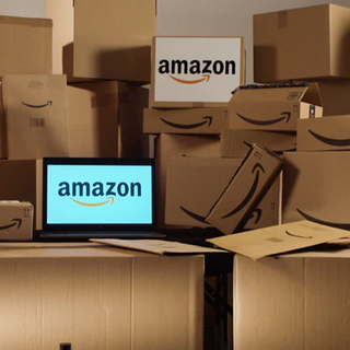 Bildschirm mit Amazon-Logo, drum herum Pakete