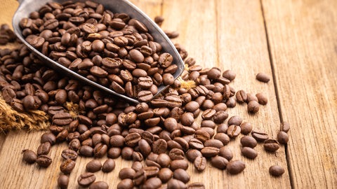 Kaffeebohnen liegen auf Holztisch