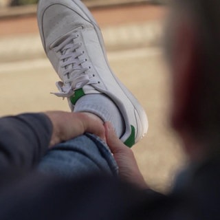 Ein Mann hält sich den schmerzenden Fuß