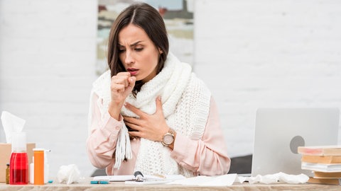 Hustende Frau. Hustenreiz und abgeschlagen: Wie lassen sich Beschwerden durch gereizte Atemwege lindern, wann ist ein Arztbesuch nötig? Welche Hausmittel helfen, und wann Antibiotika nötig sind.