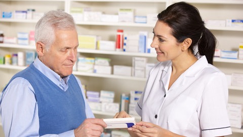 Ein Mann lässt sich von einer Apothekerin beraten.