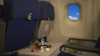 Flugzeugsitzplatz mit flaschen auf dem Tisch