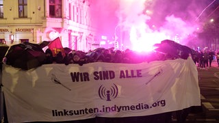 Demonstranten mit Indymedia-Plakat
