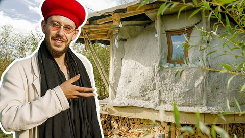 Simon steht vor seinem selbstgebauten Haus aus Lehm