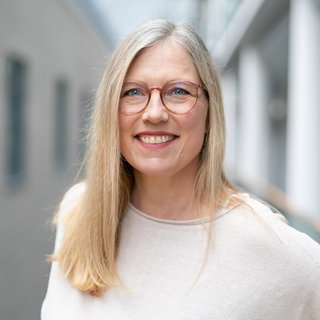 Eine Frau mit blonden Haaren lacht in die Kamera. Tina Bonin arbeitet als Autorin und Redakteurin ARD Room Tour in Mainz.