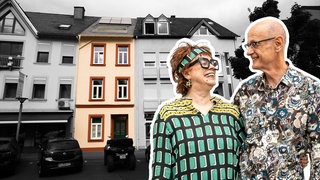 Ein Paar in bunt gemusterten Hemden lächelt sich an, im Hintergrund ist ein schmales Stadthaus zu sehen, das zwischen zwei anderem Häusern steht.