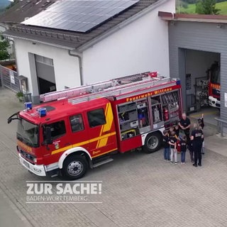 Feuerwehrauto vor einem Feuerwehrhaus