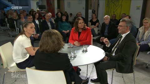 Moderatorin Alexandra Gondorf mit Gästen an einem Tisch