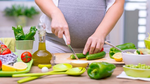 Eine Schwangere bei der Zubereitung von Essen