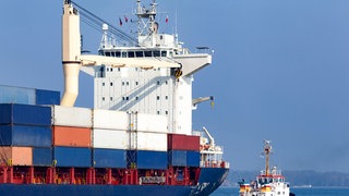 Containerschiff neben kleinem Schlepper: Warum befindet sich die Kommandobrücke bei Schiffen mal hinten, mal vorne, mal in der Mitte?
