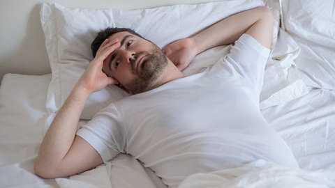 Mann beim Aufwachen: Noch rätseln Forscherinnen und Forscher, wieso wir Träume so schnell vergessen