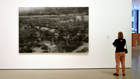 "Beerdigung" (1988) zeigt die Beisetzung von Andreas Baader, Gudrun Ensslin und Jan-Carl Raspe. – Mit dem Episkop projiziert Richter fotografische Vorlagen in Vergrößerung auf die Leinwand, zeichnet die Umrisse ab, malt die Flächen aus und verwischt die Farben. Die Bilder wirken wie mit dem Weichzeichner aufgenommen, wie verblasst, abgegriffen oder retuschiert.