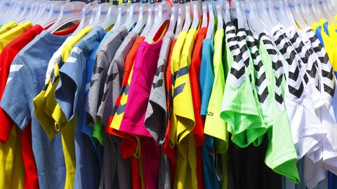  Bunte T-Shirts auf Kleiderbügeln hängend