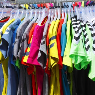  Bunte T-Shirts auf Kleiderbügeln hängend