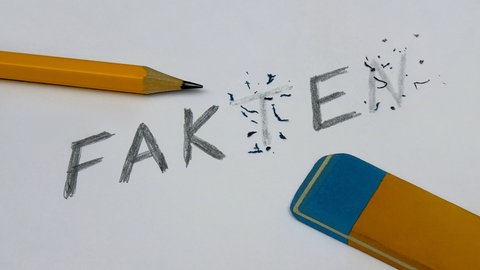 Mit einem Bleistift wurde der Schriftzug Fakten geschrieben und mit einem Radiergummi wurden Buchstaben wegradiert, sodass der Schriftzug Fake übrig blieb.
